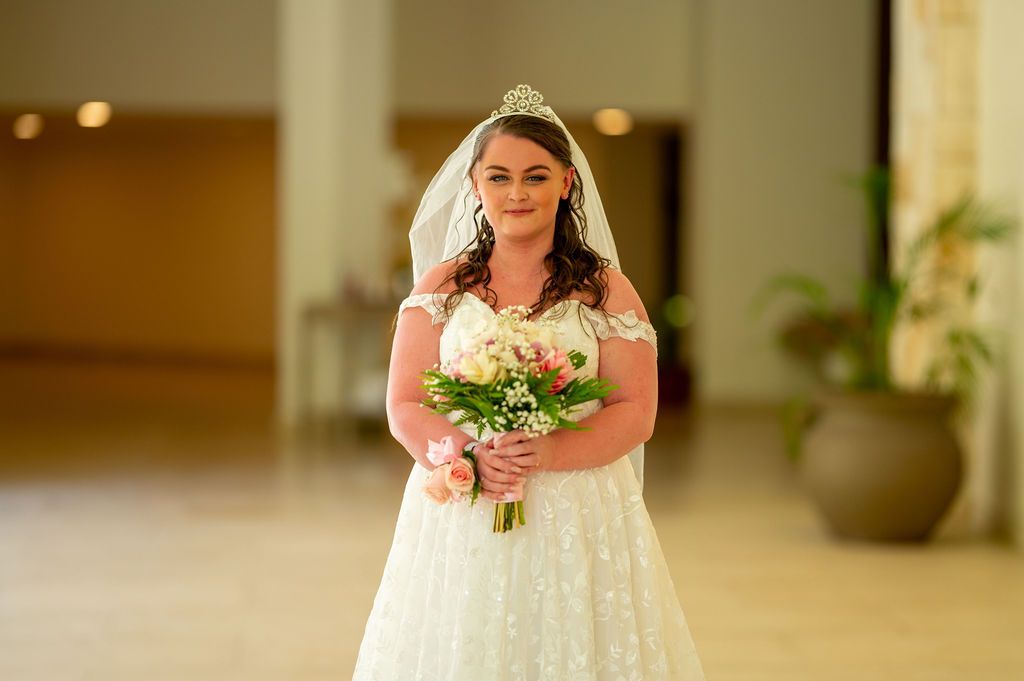 Bride's hand with engagement ring and bouquet